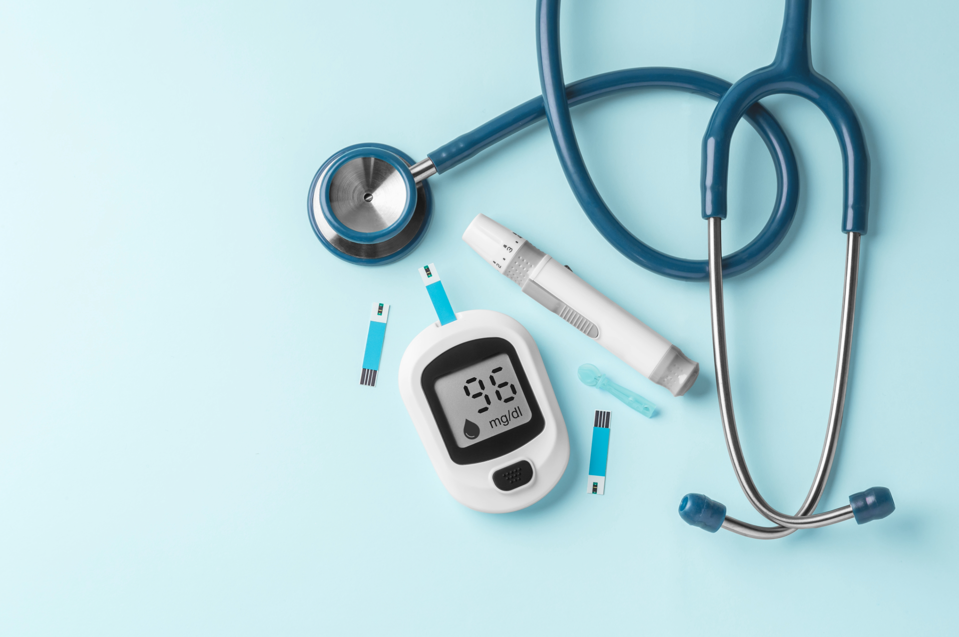Medical tools for diabetes, including a stethoscope, blood glucose monitor, and lancets on a blue background.