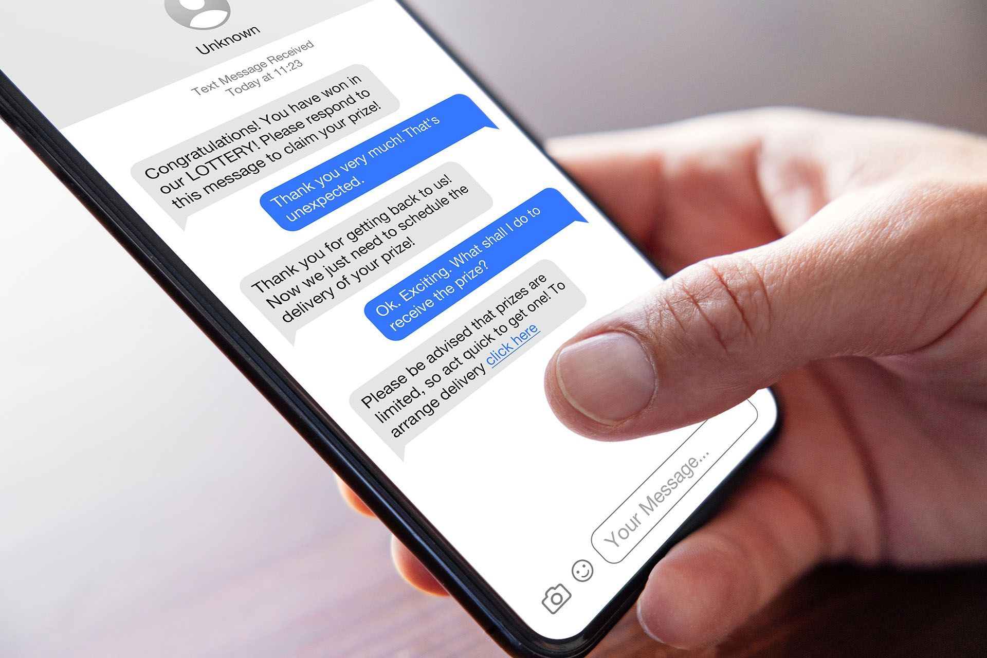 A person is holding a cell phone with text messages on it.