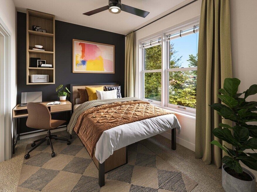 Modern bedroom featuring a bed with a textured brown blanket, a corner desk, wall shelving, and a large window with drapes.