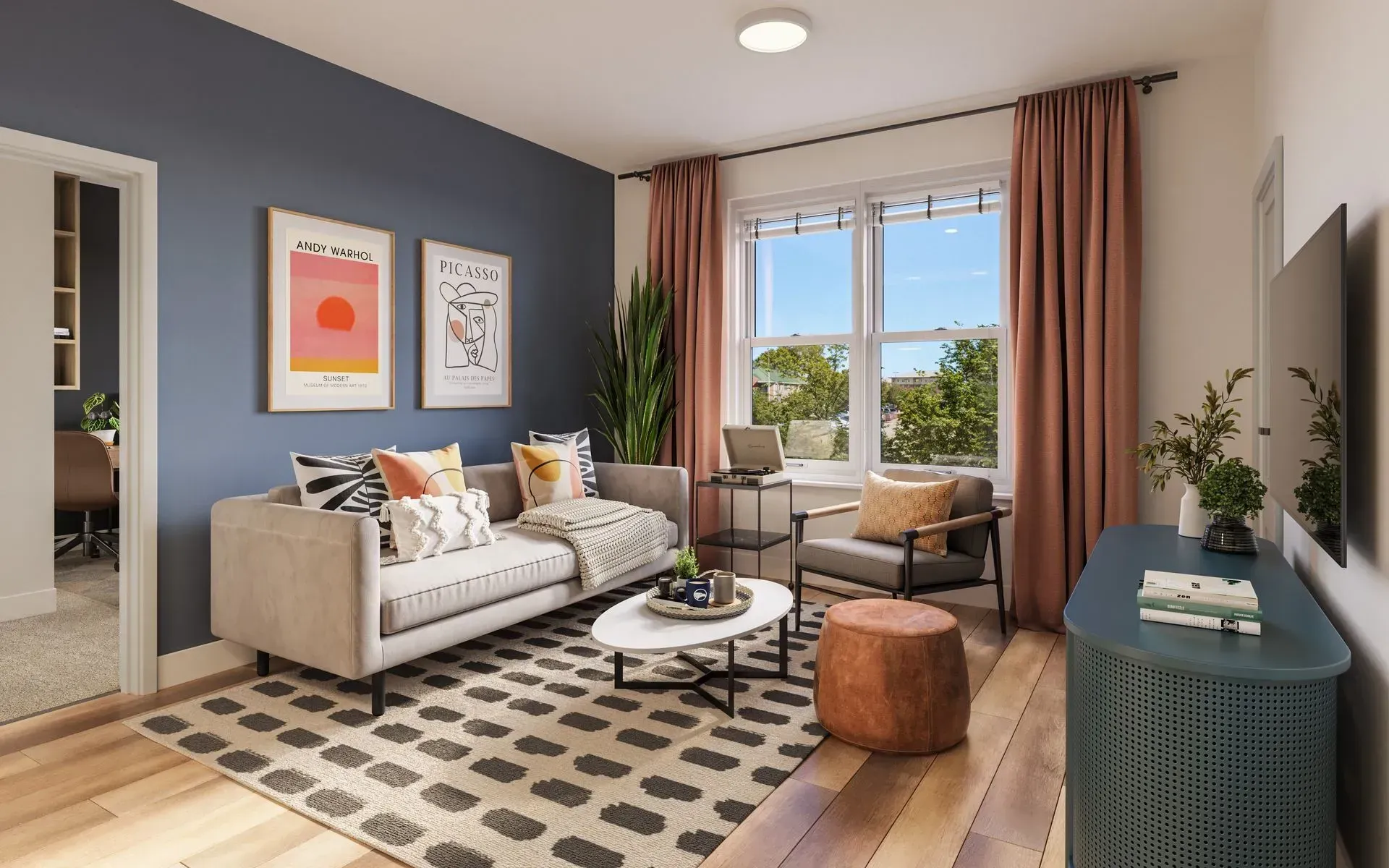 Living room in a contemporary apartment with a blue accent wall, sofa, and large window.