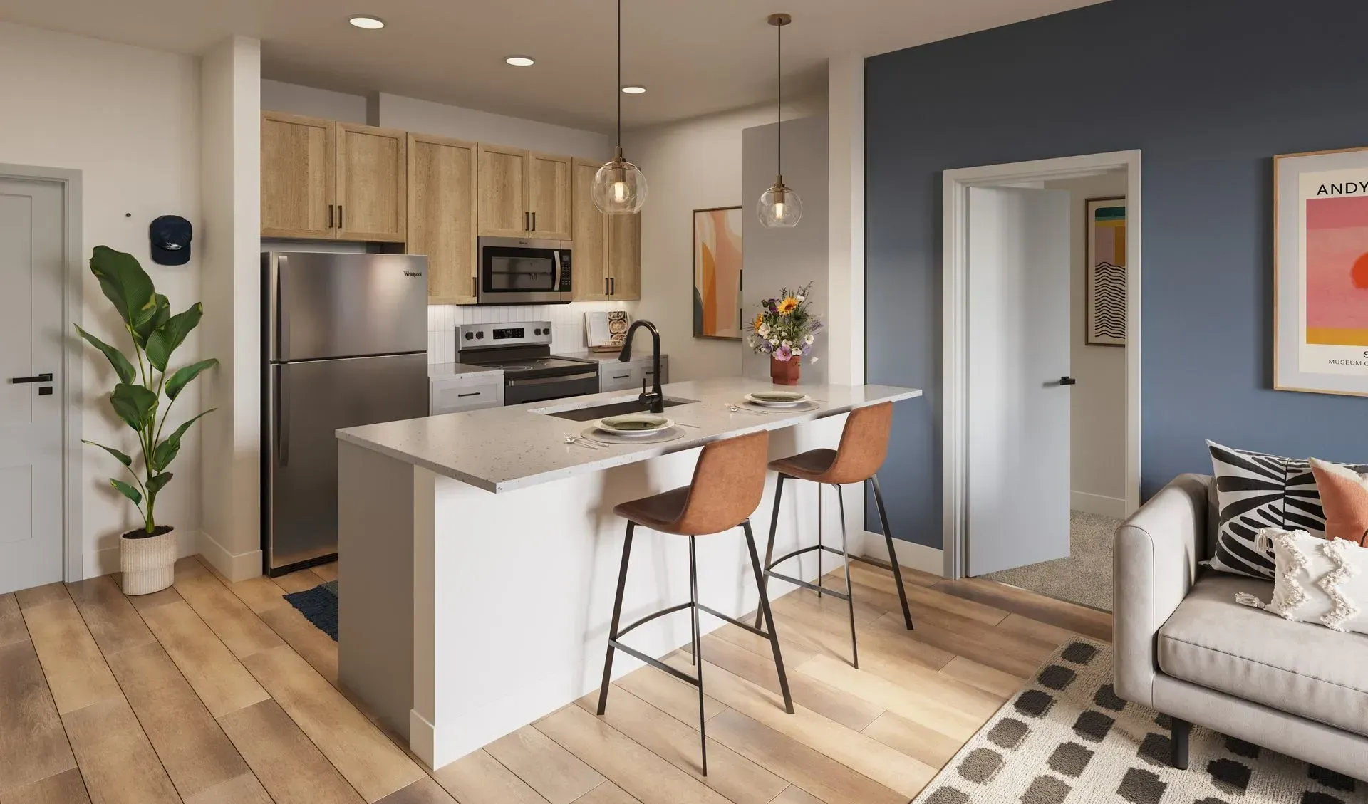 Modern kitchen with island, pendant lights, and stainless-steel appliances in an open living space.
