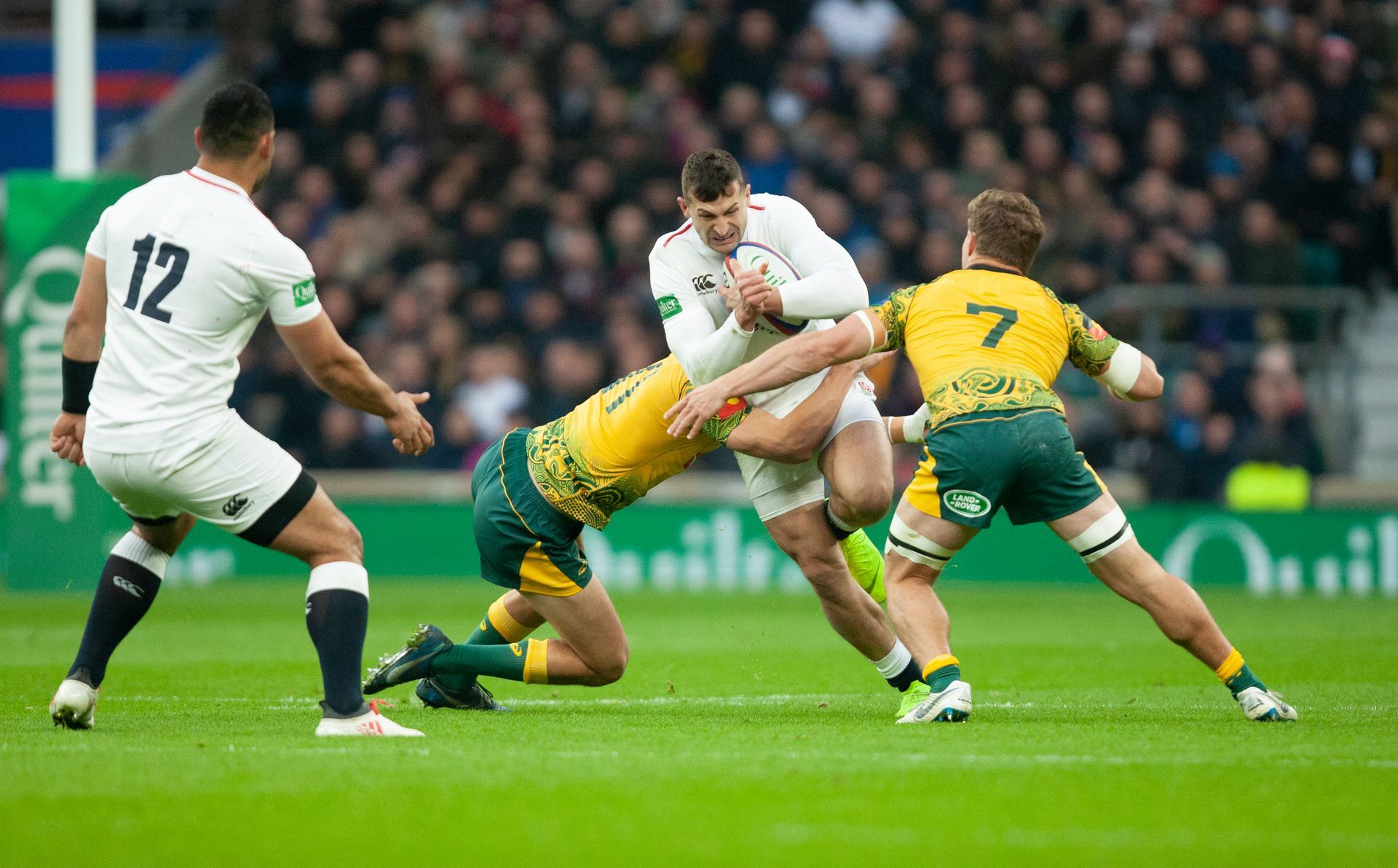 A group of rugby players are playing a game on a field.