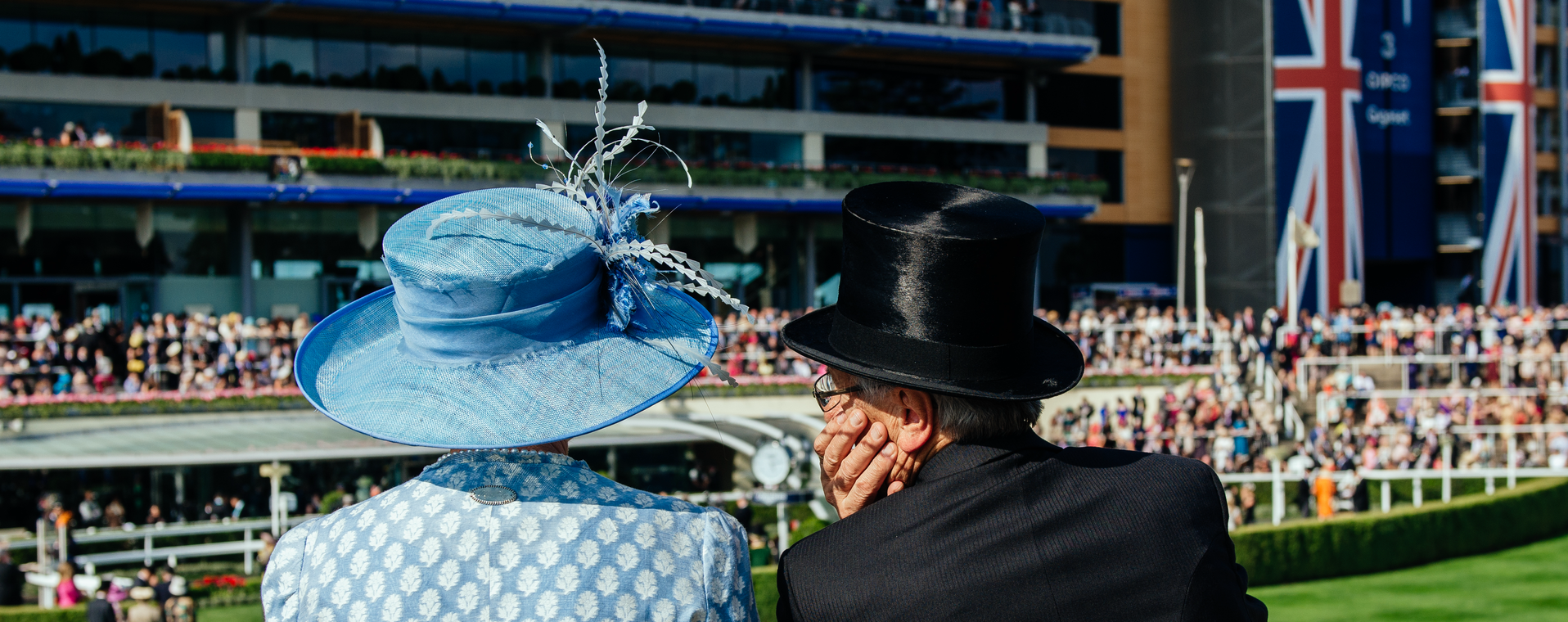 Elegant guests enjoying a thrilling horse race at Royal Ascot 2025, with vibrant hats and formal attire in a luxurious VIP enclosure.