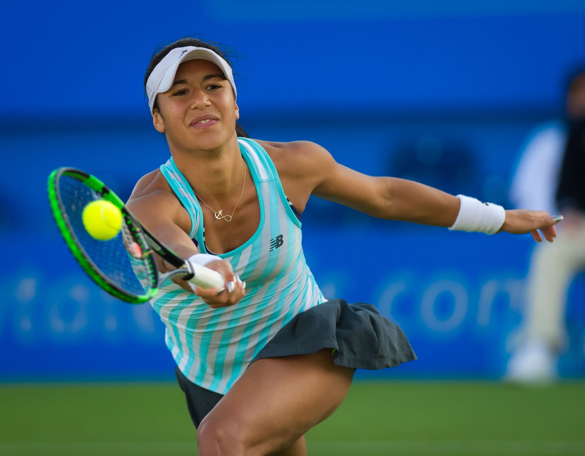 A woman is swinging a tennis racket at a tennis ball
