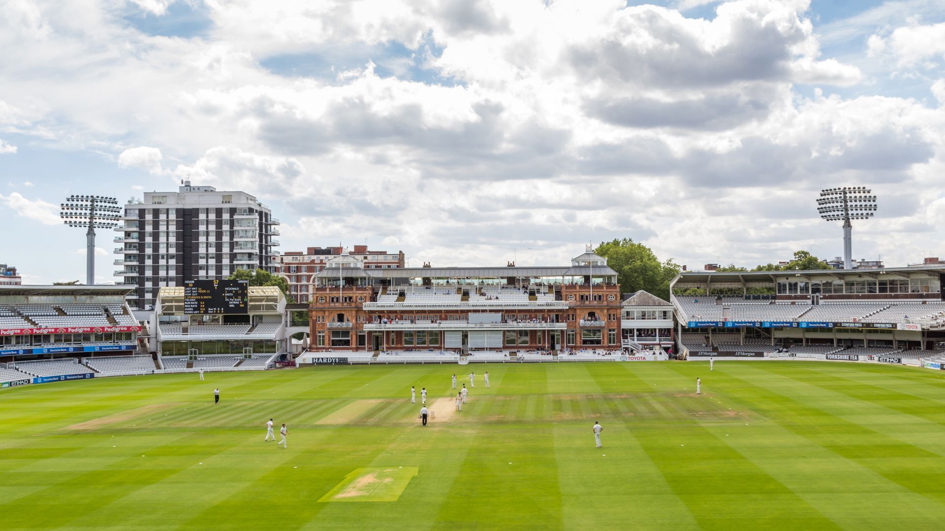 A cricket match is being played on a lush green field.