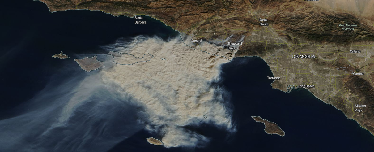 A satellite image of a large cloud of smoke over a large body of water.