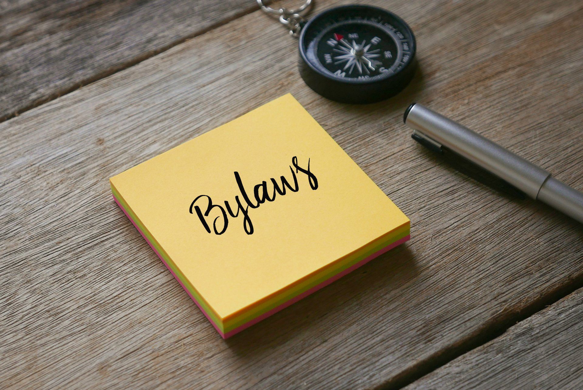 A yellow sticky note with the word bylaws written on it