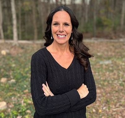 A woman in a black shirt is smiling for the camera.