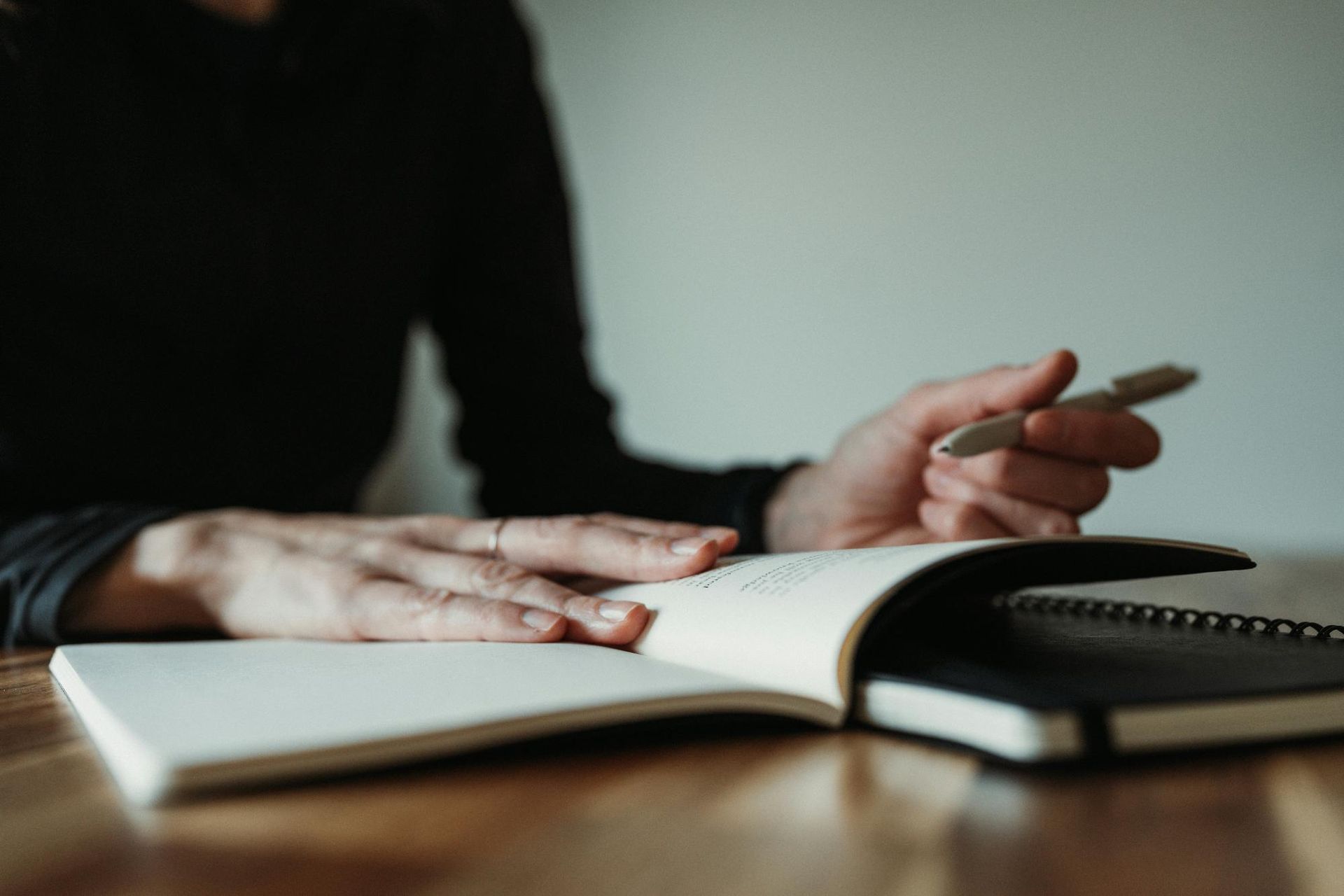 Woman writing in a notebook symbolizes the process of leading with vision in writing