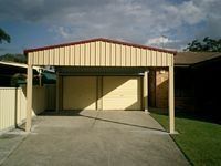 A garage with a canopy over it is in front of a house.
