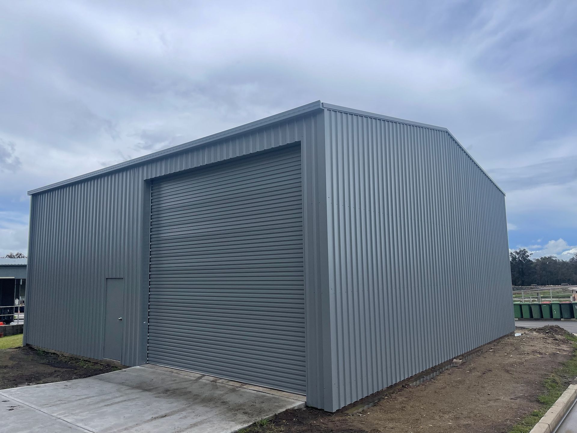 A large gray metal building with a large garage door.