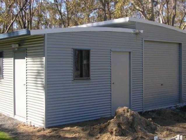 A small building with a garage door and a window