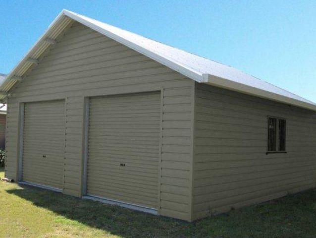 A garage with two garage doors and a white roof