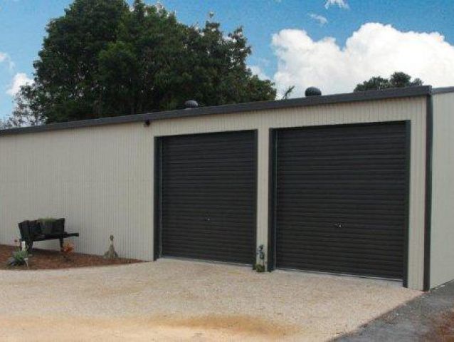 A white garage with two black garage doors