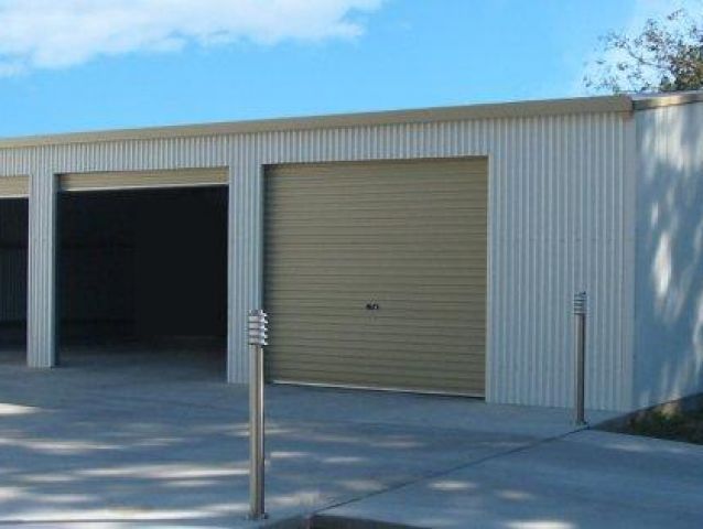 A row of cream garage doors with a blue sky in the background