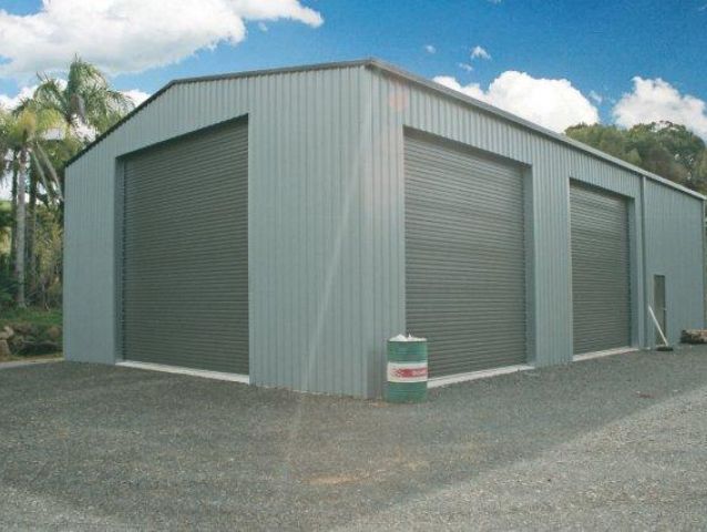 A garage with a green barrel in front of it