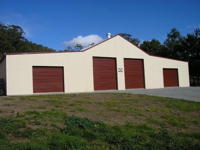 A white building with red garage doors has the number 52 on the side