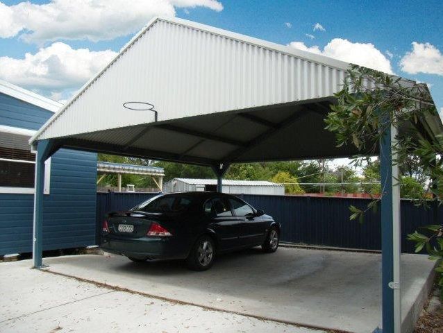 A black car is parked under a white carport