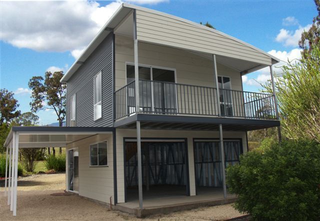 A house with a balcony and a garage underneath it