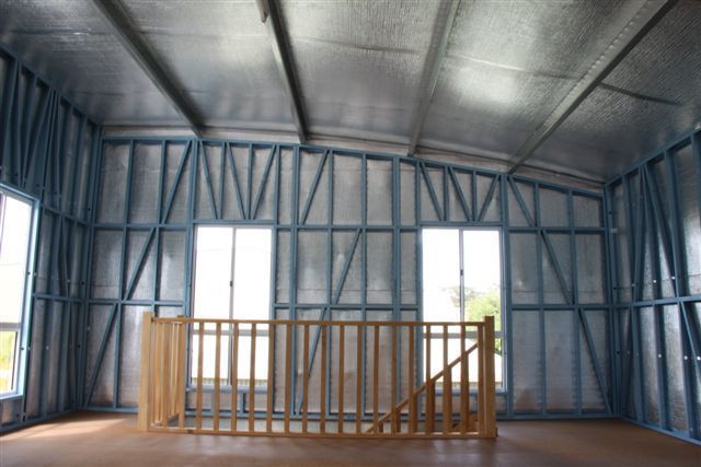 An empty room with a wooden railing and lots of windows