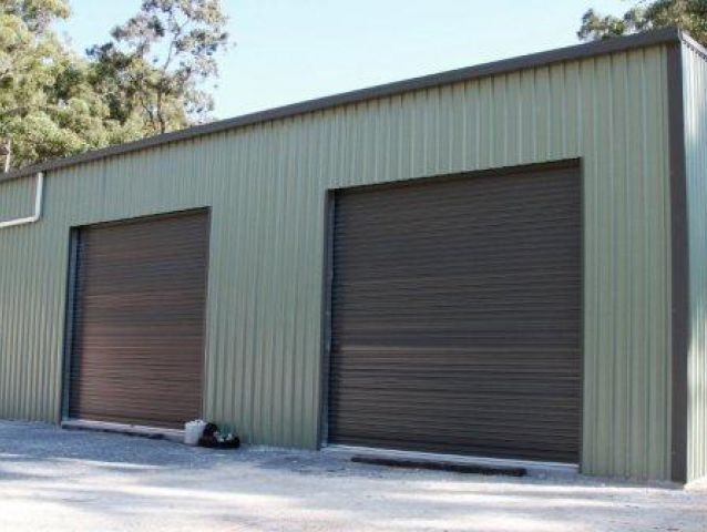 There are two garage doors on the side of a building.