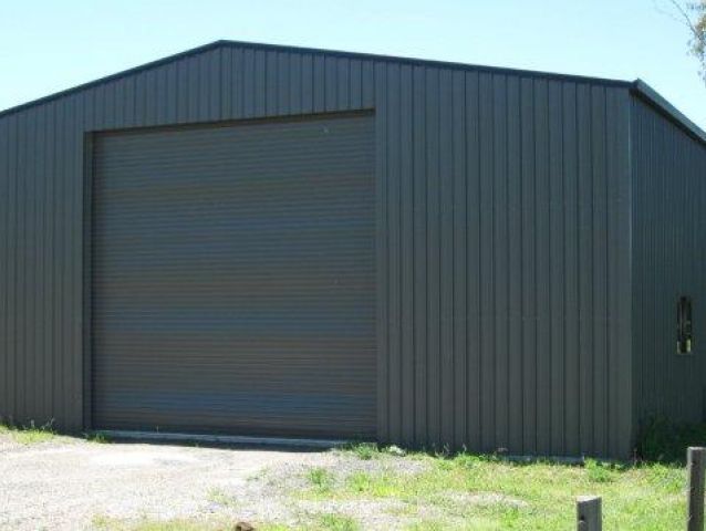 A large gray building with a large garage door