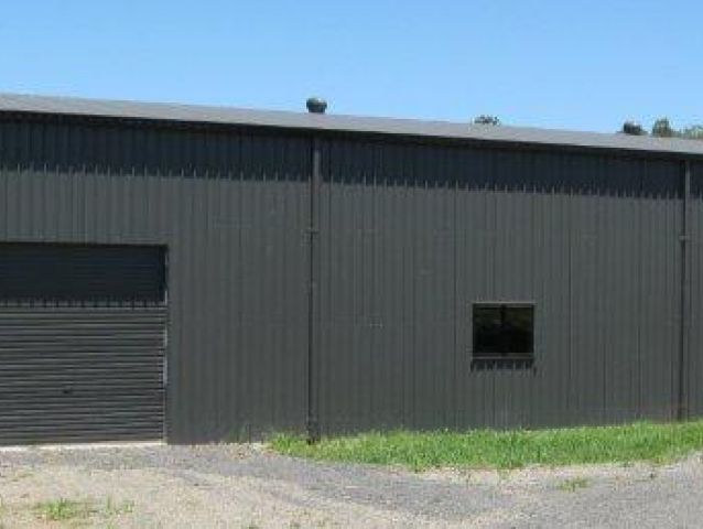 A large black building with a garage door and a window.
