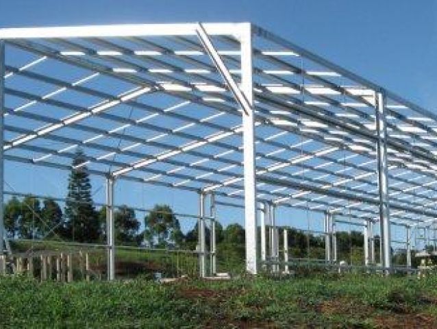 A large metal structure is being built in a field