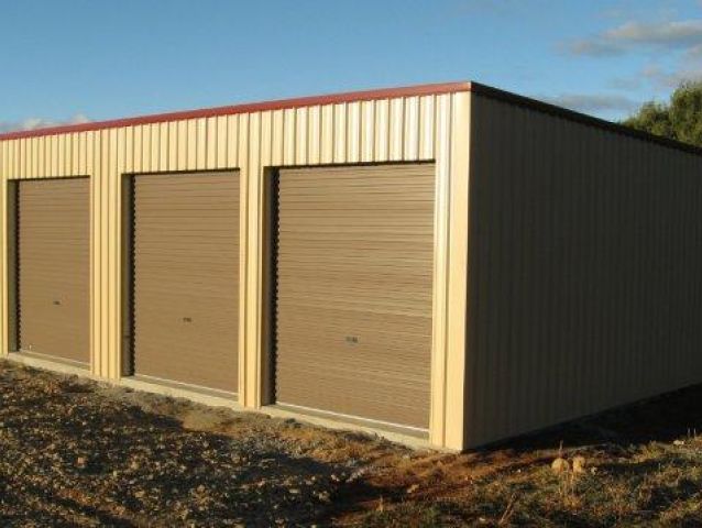 A row of garage doors with a blue sky in the background