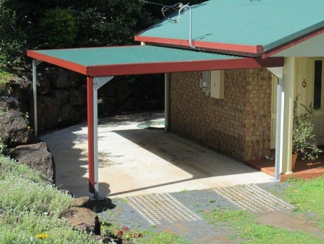 A house with a green roof and a carport