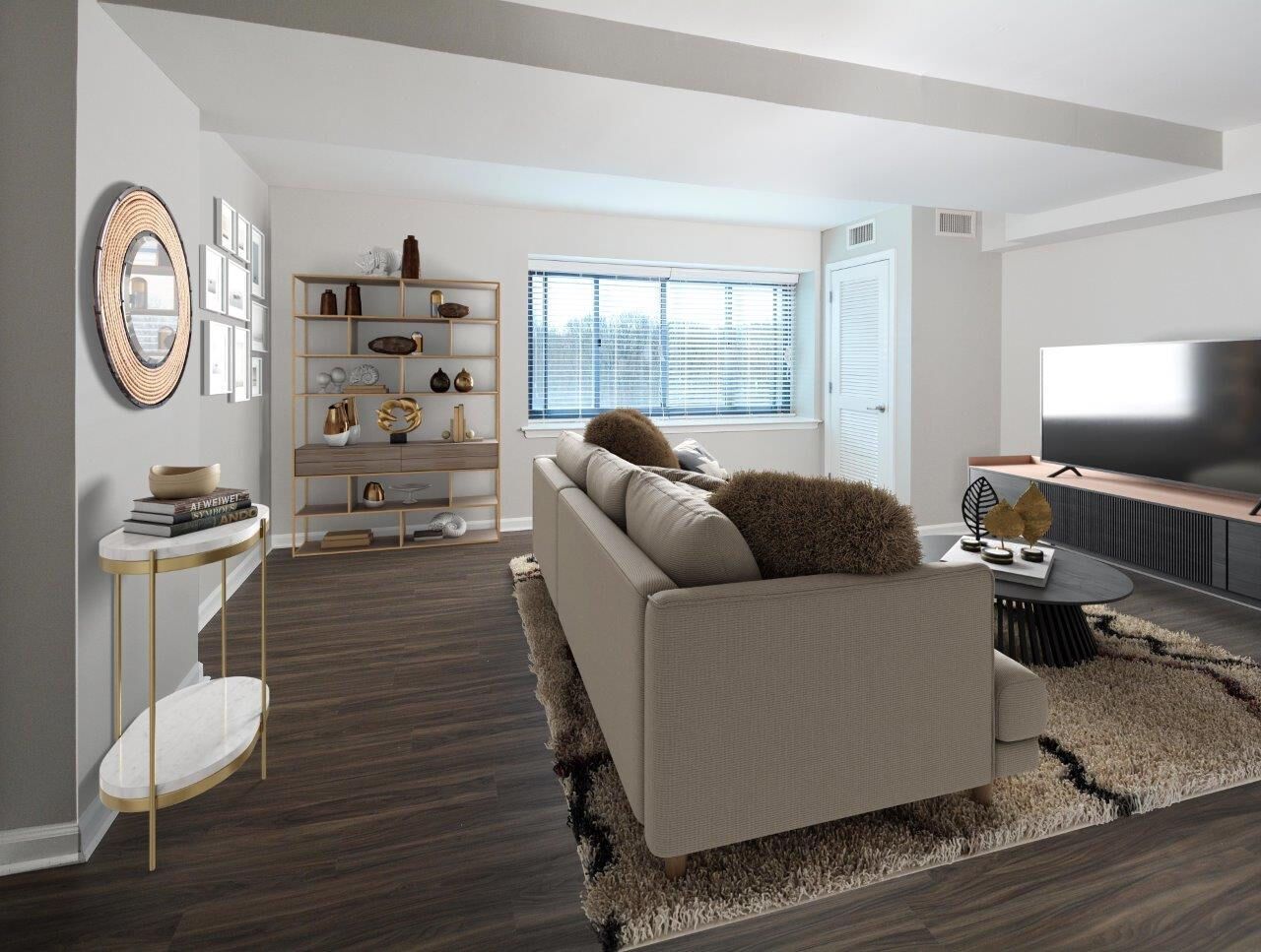 Living room in a modern apartment with a beige sofa, dark wood floor, shelves, and a large TV.