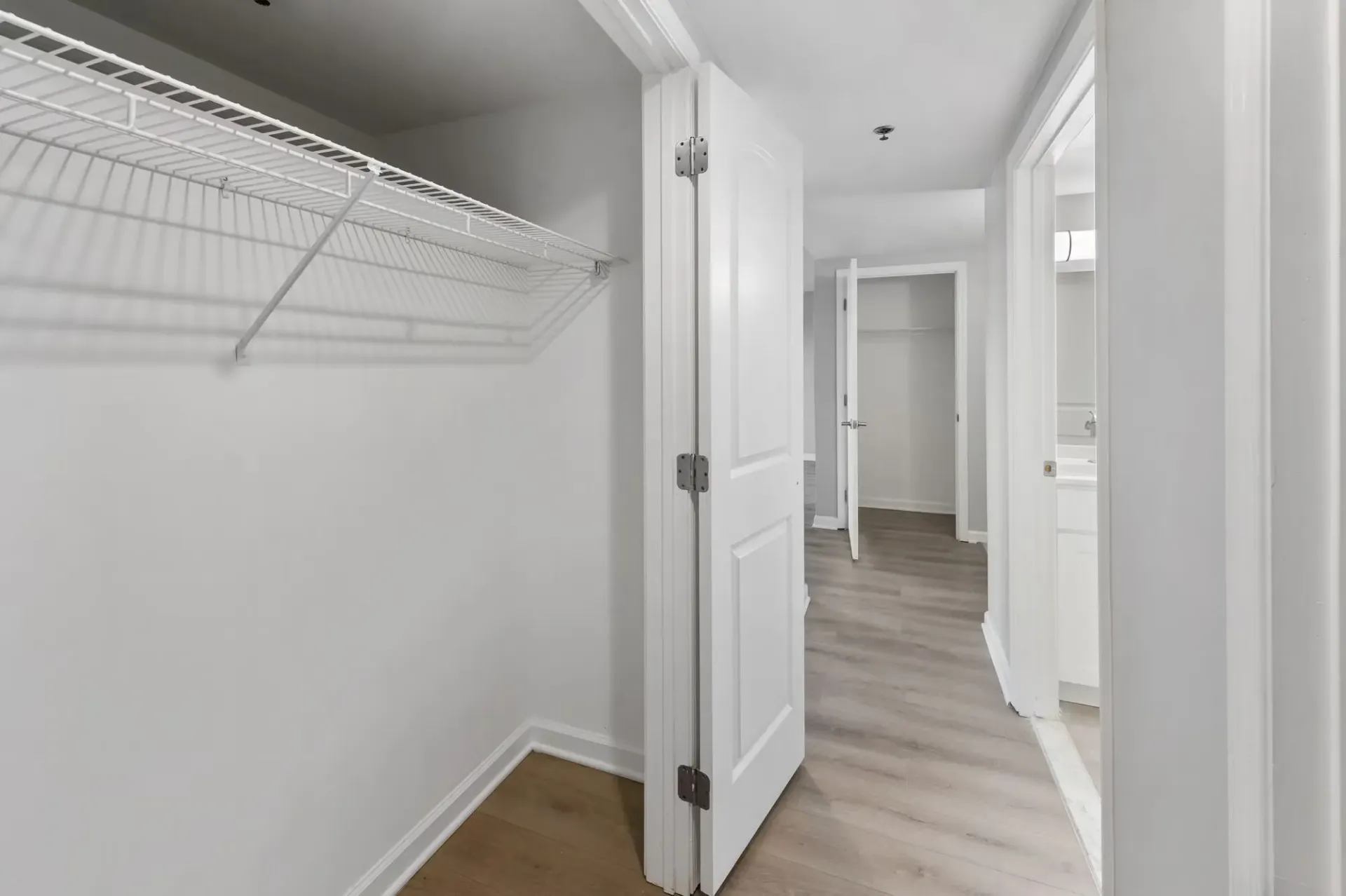 Closet with wire shelving in a bright apartment hallway.