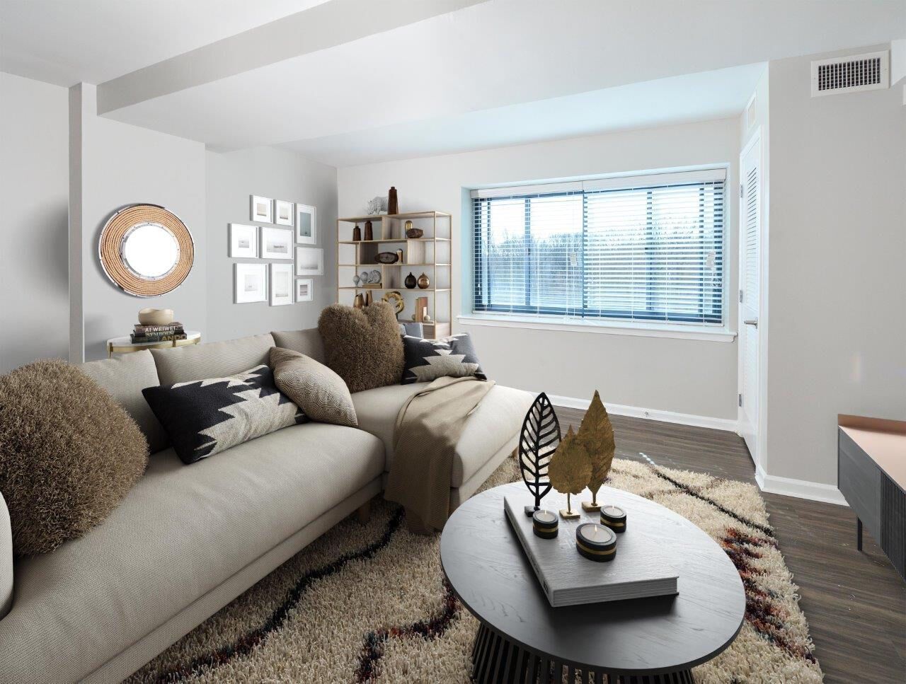 Living room in a modern apartment with beige sofa, decorative cushions, and window blinds.