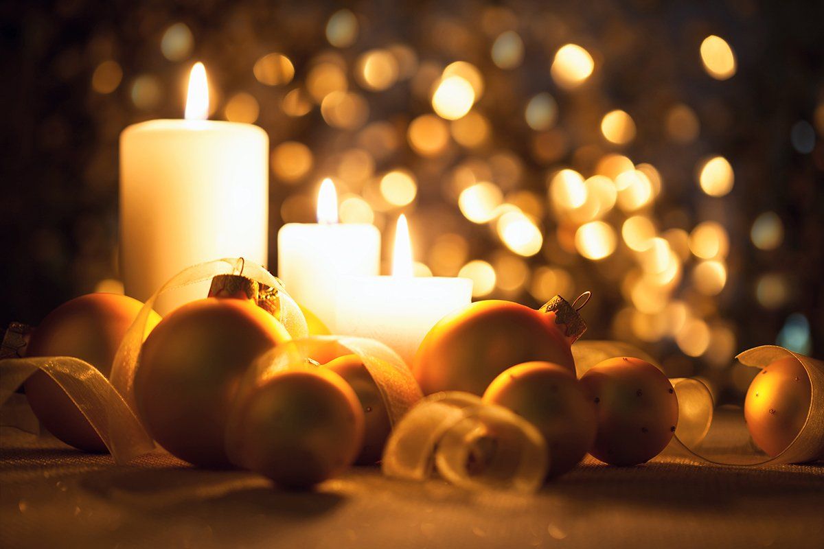 three burning candles with ornaments and ribbon