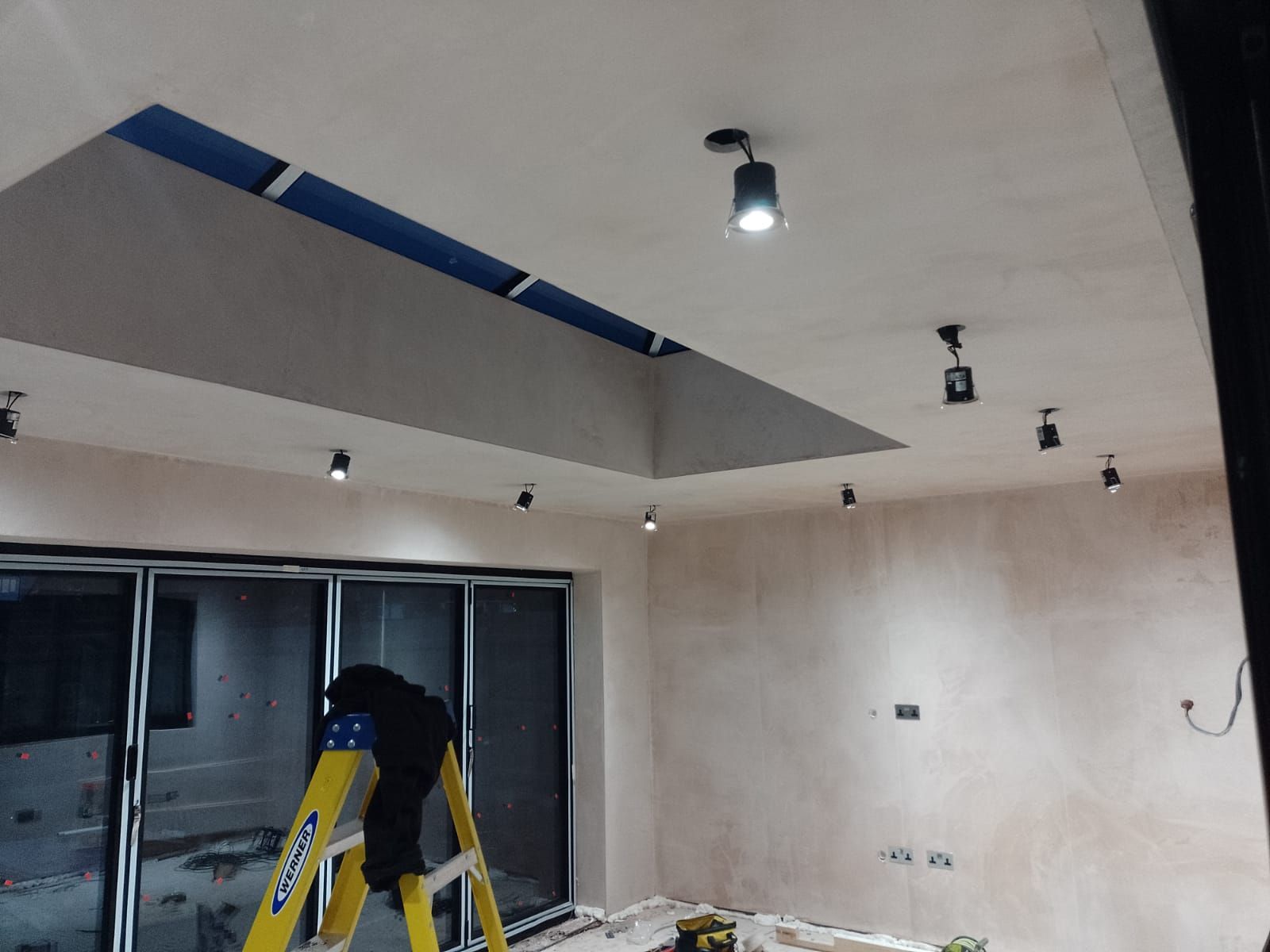 Downlights being installed in an  extension with  large ceiling window