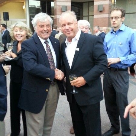 A man in a suit shakes hands with another man