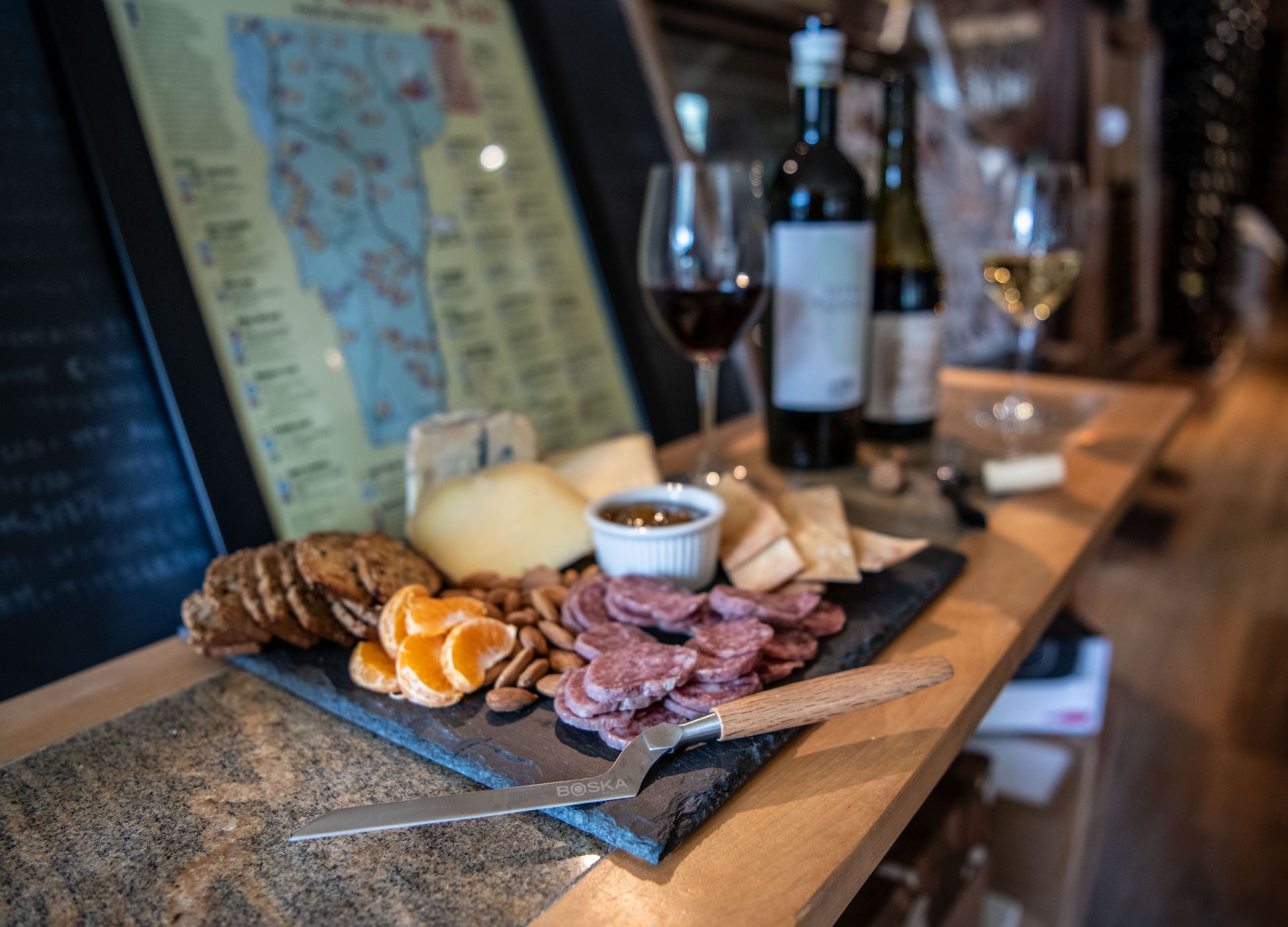 A tray of charcuterie and wine on a wooden table at Wine & Cheese Depot