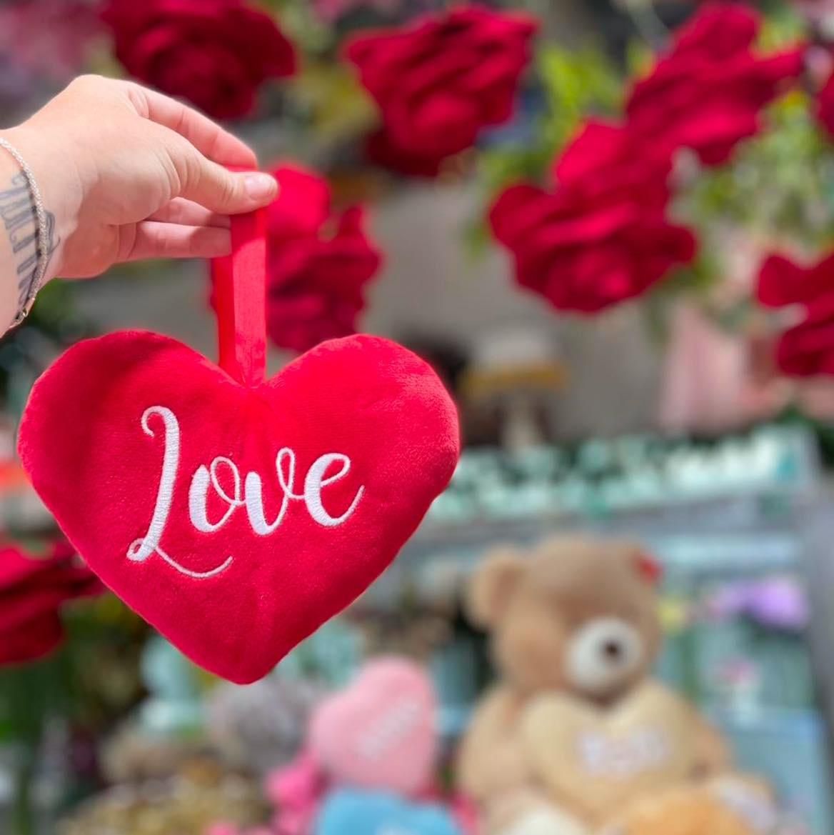 A Person is Holding a Red Heart With the Word Love on It — Floret In Lismore, NSW