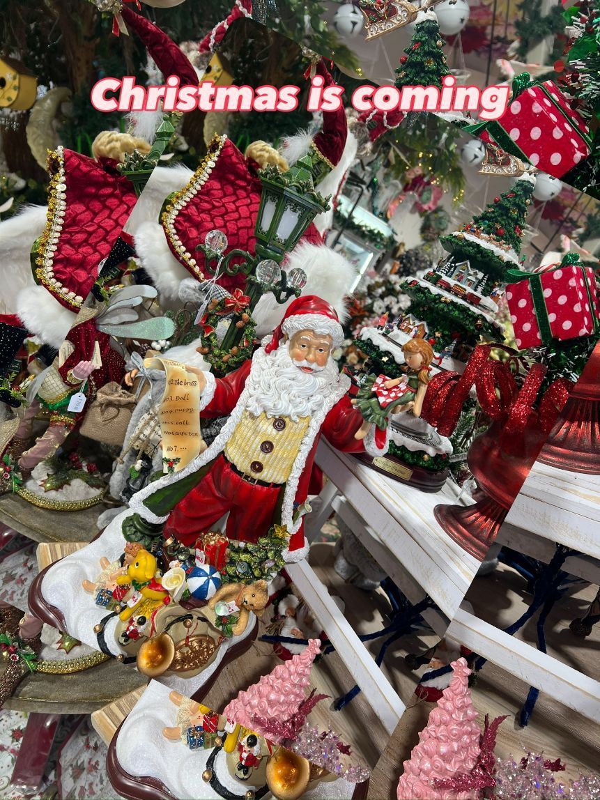 Santa figure surrounded by festive Christmas decorations in a shop window display.
