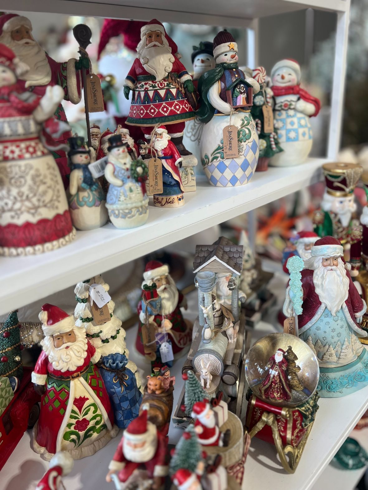 Shelves of Christmas figurines: Santa Clauses and snowmen in various styles.