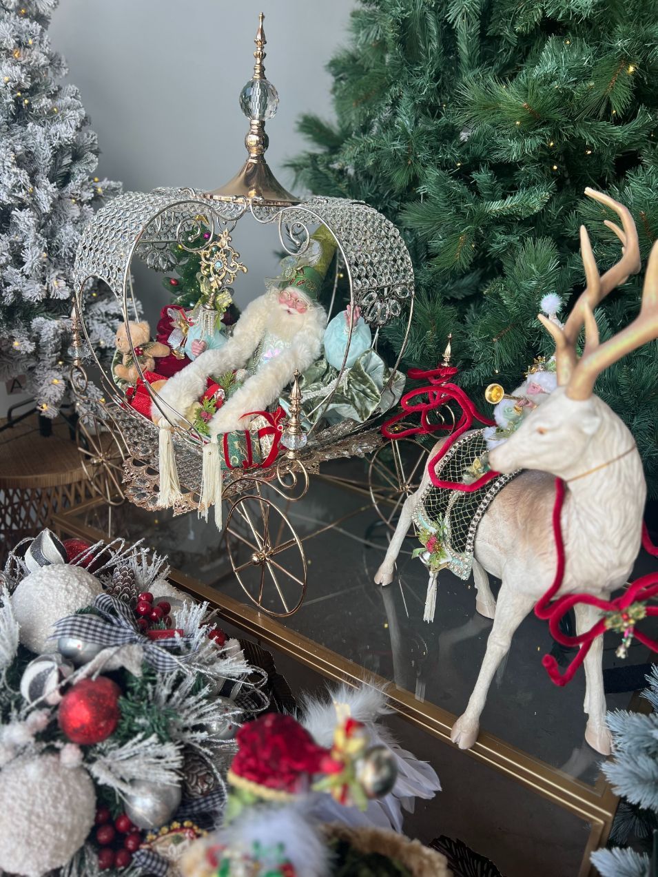 Christmas display with reindeer, carriage, and ornaments.