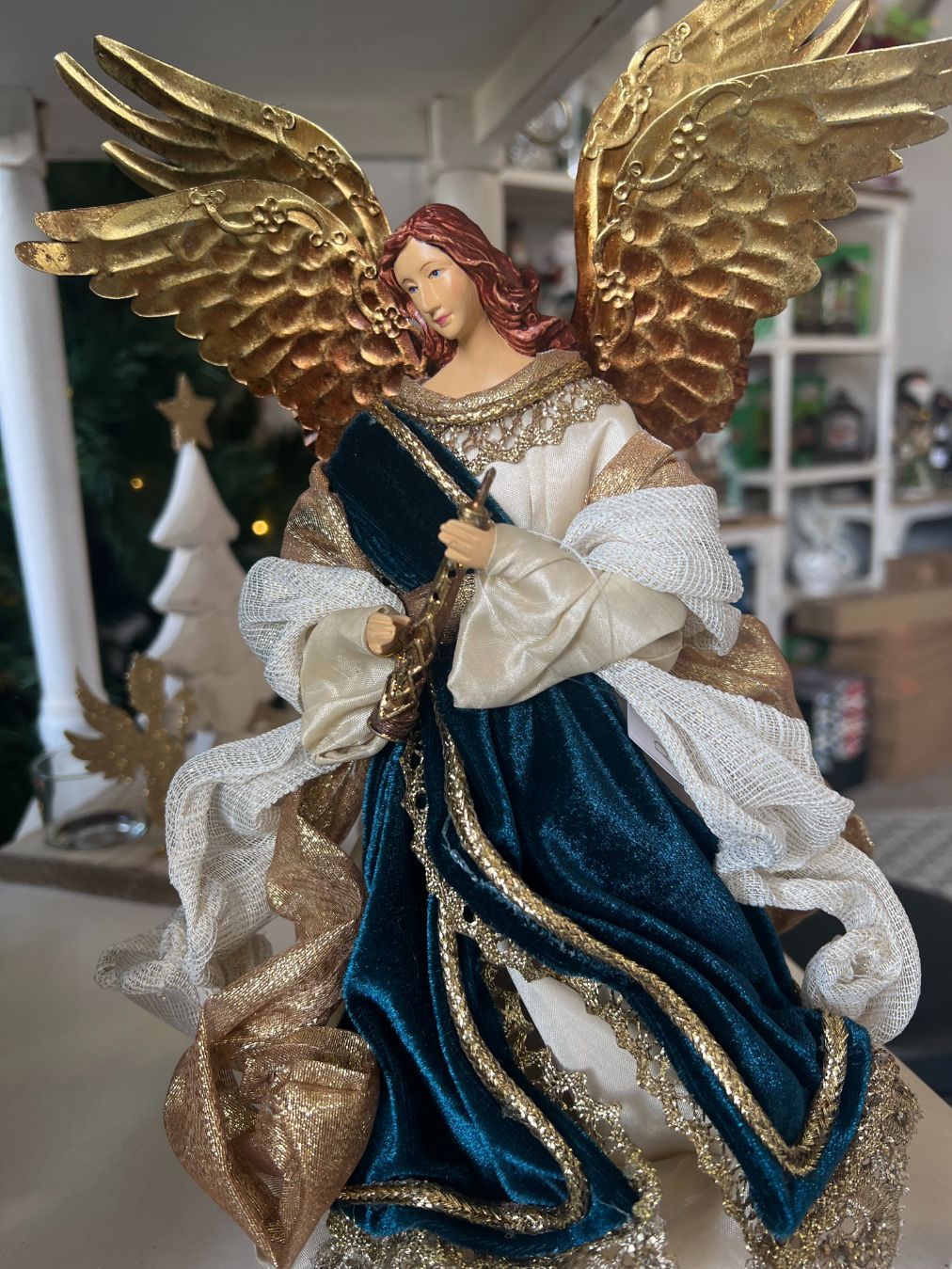 Golden-winged angel Christmas tree topper, teal dress, cream robe, gold trim, and auburn hair.