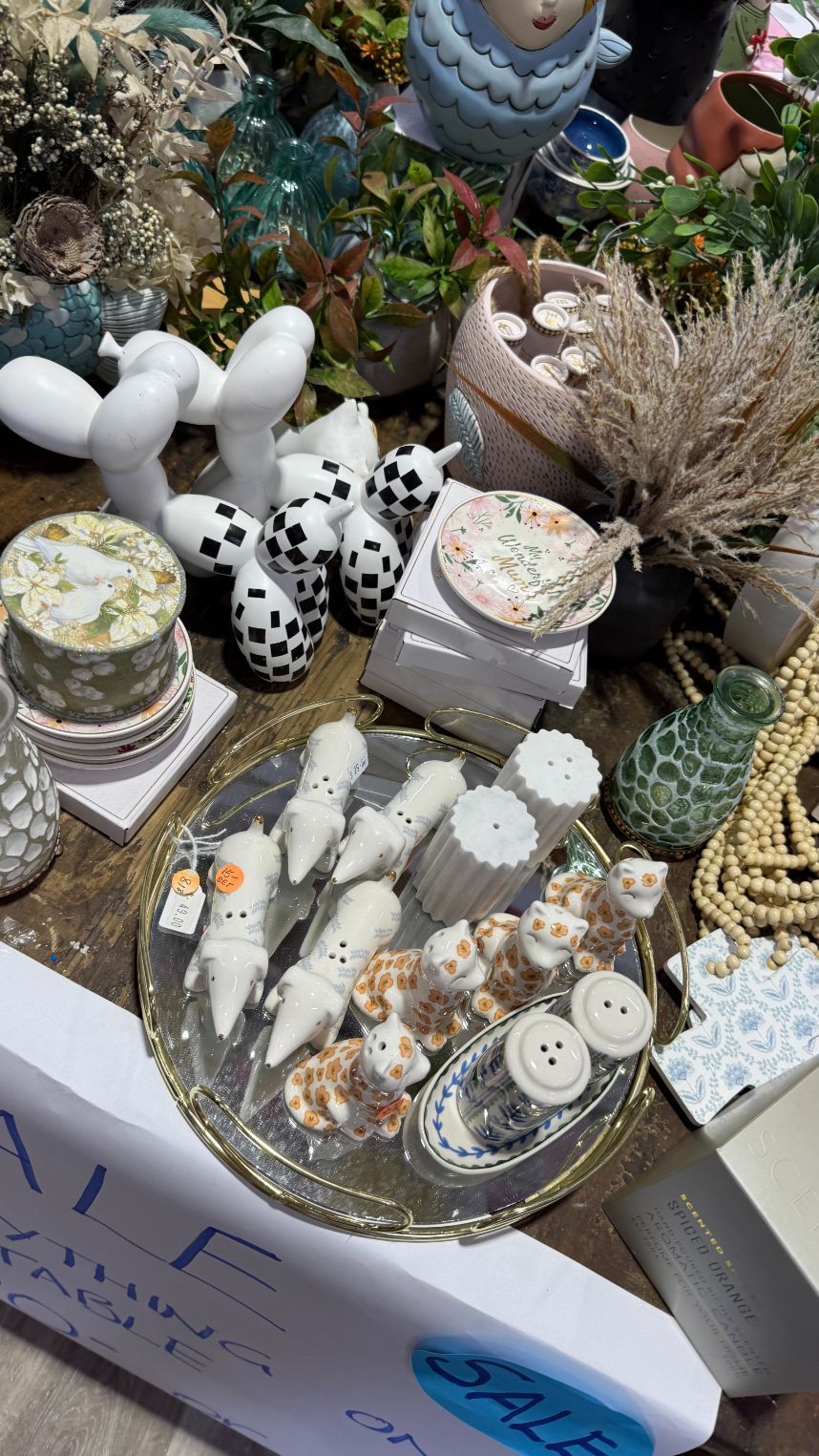 Tabletop display of ceramic and decorative items, including animal figurines and teacups.
