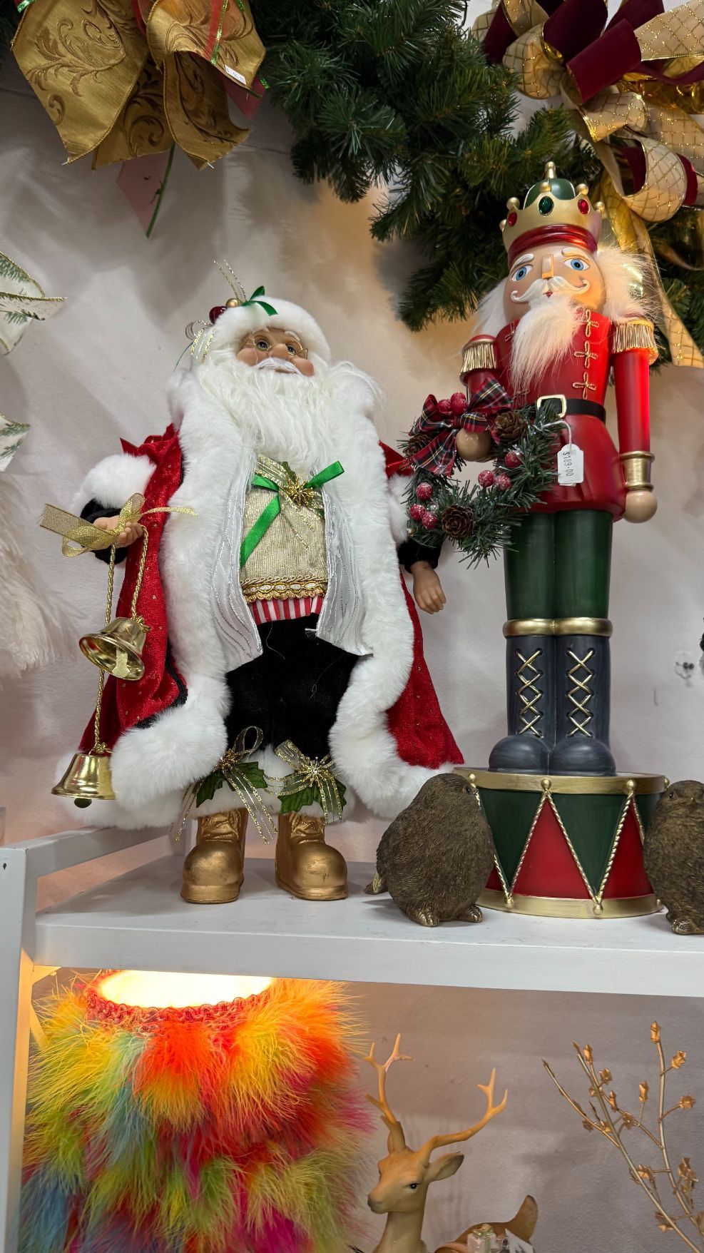 Santa Claus figure beside a nutcracker, both Christmas decorations on a shelf.
