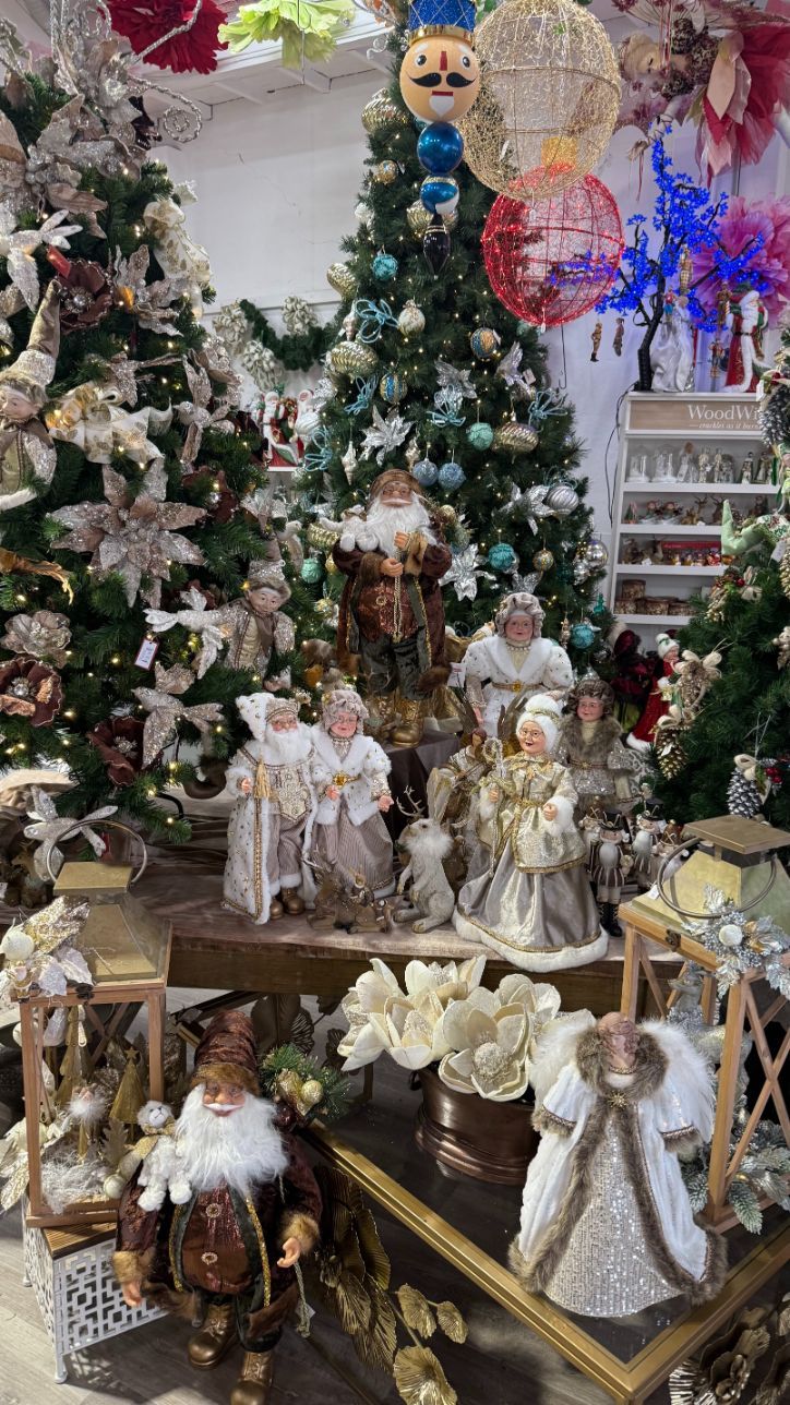 Christmas display with decorated trees, figurines, and ornaments in a store.
