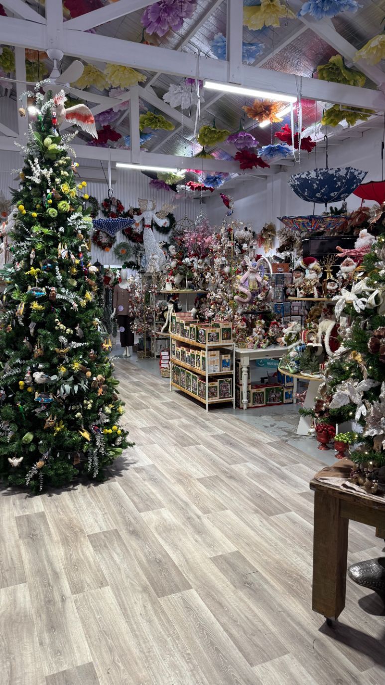 Christmas decorations and gift shop with trees, displays, and umbrellas on the ceiling.