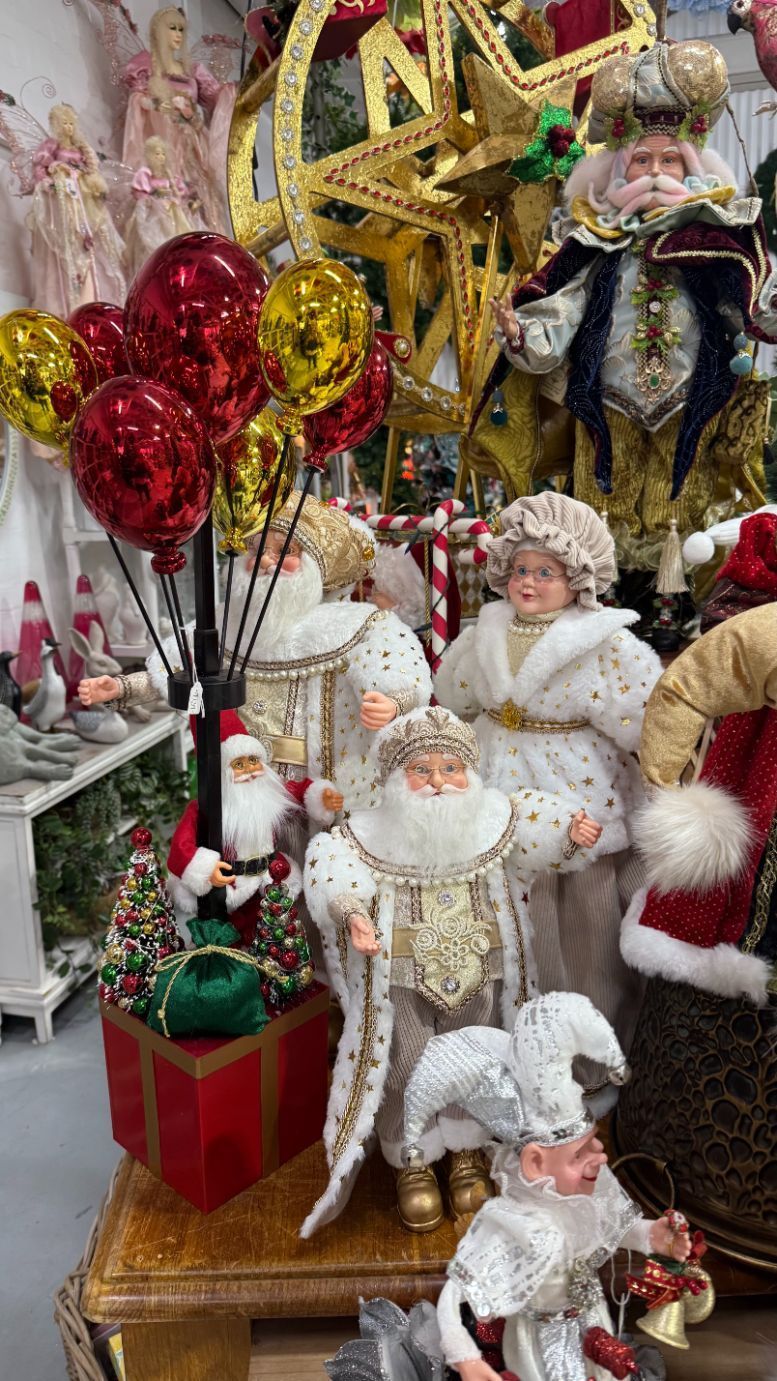 Christmas decorations on display: Santa figures, star, balloons, in a store setting.