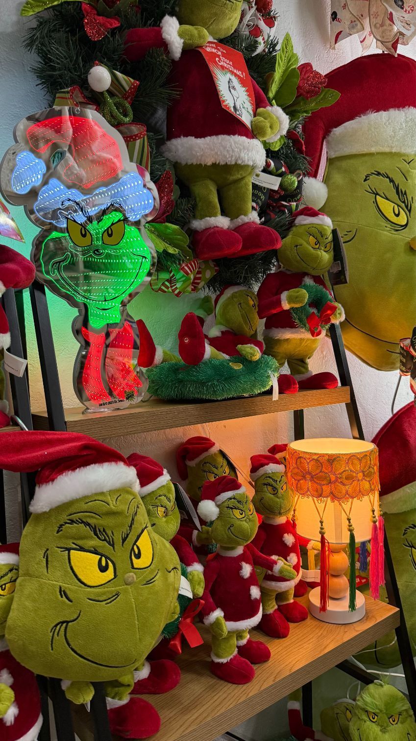 Christmas display with various Grinch figures wearing Santa hats.