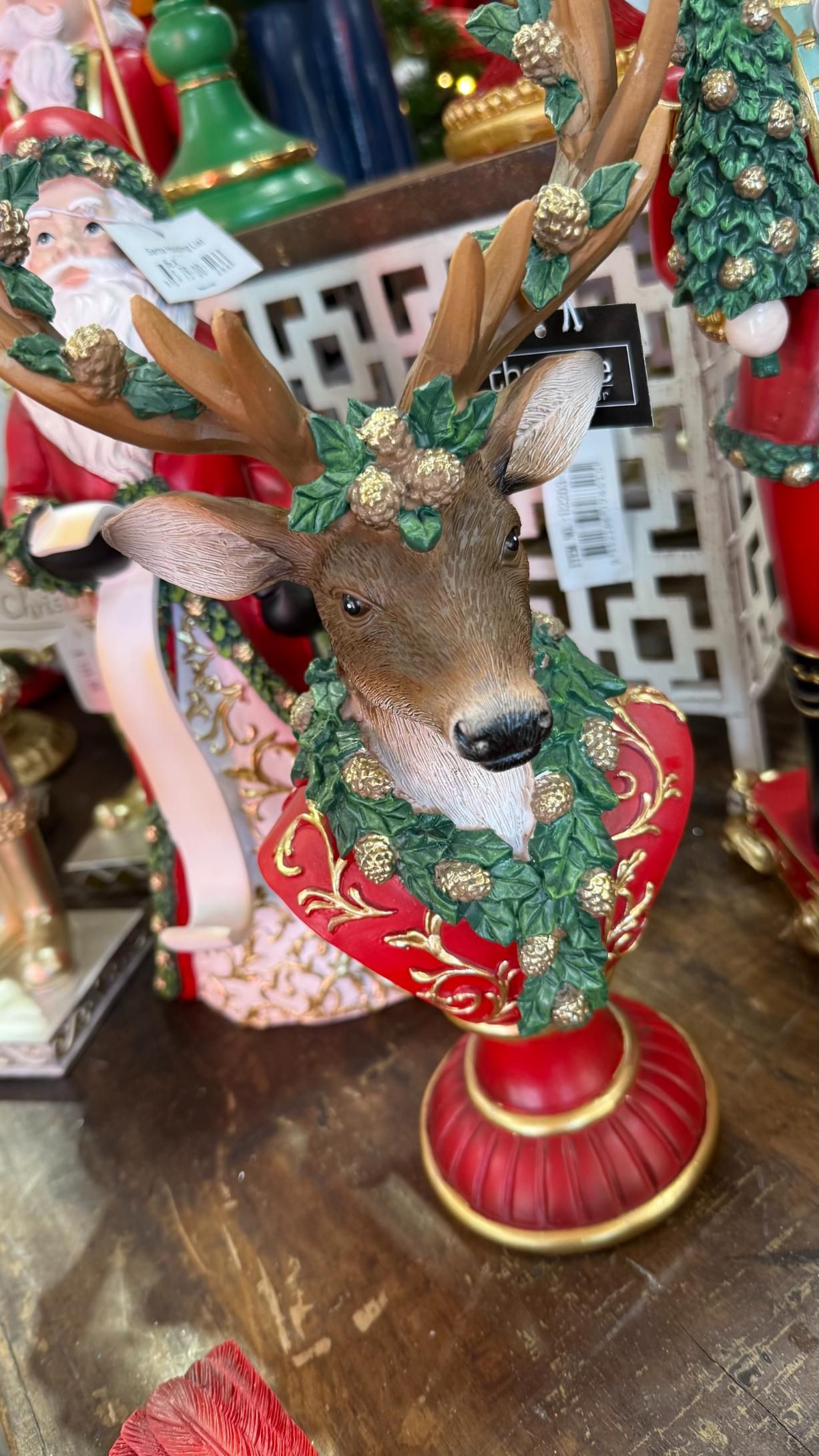 Christmas deer bust, wearing a garland, atop a red heart. Set on a red, gold-trimmed base. | Jingle Bell Christmas