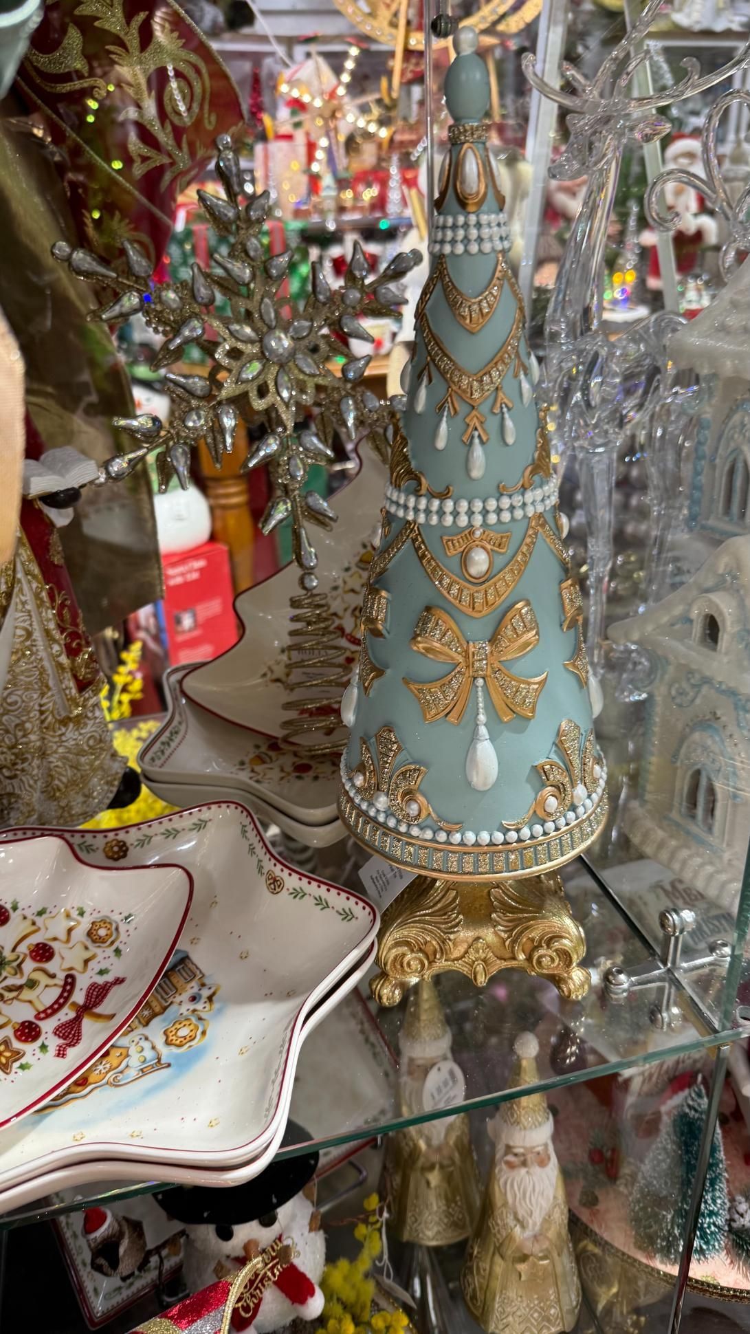 Blue and gold decorated Christmas tree figurine on a store shelf. | Jingle Bell Christmas